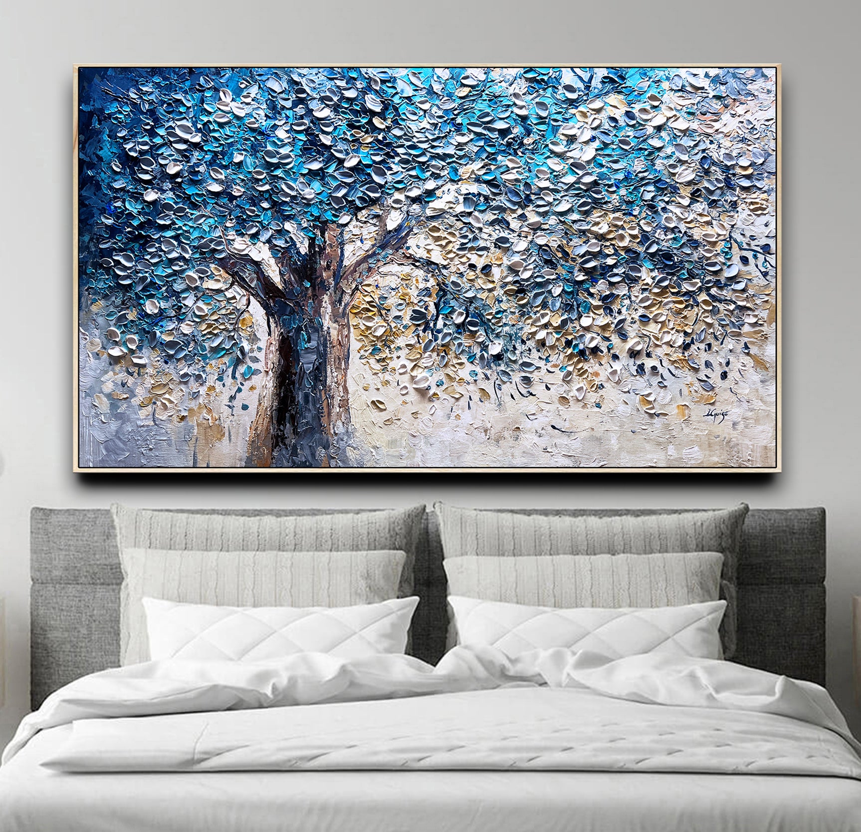 a painting of a tree on a wall above a bed