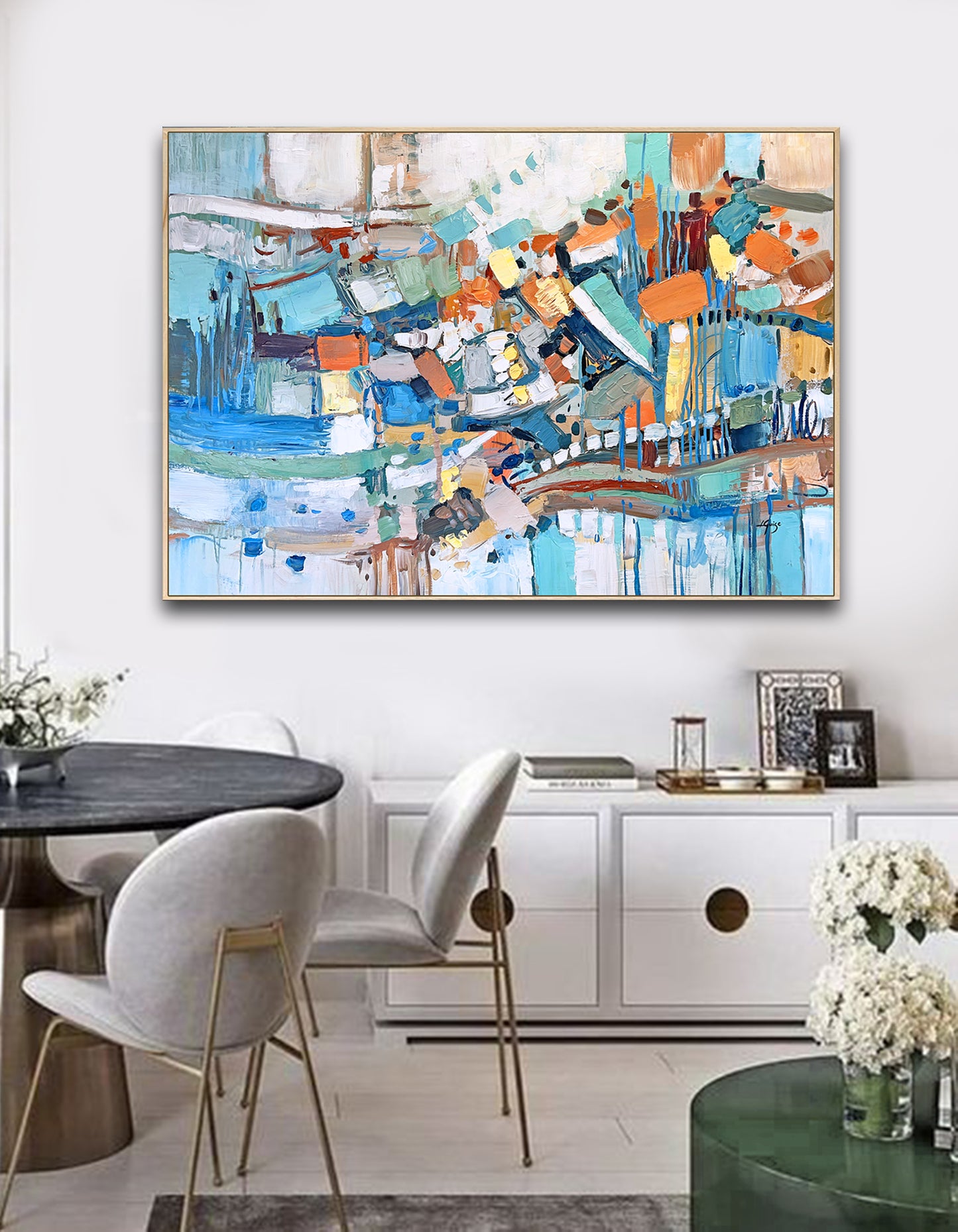 a painting hanging on a wall above a dining room table