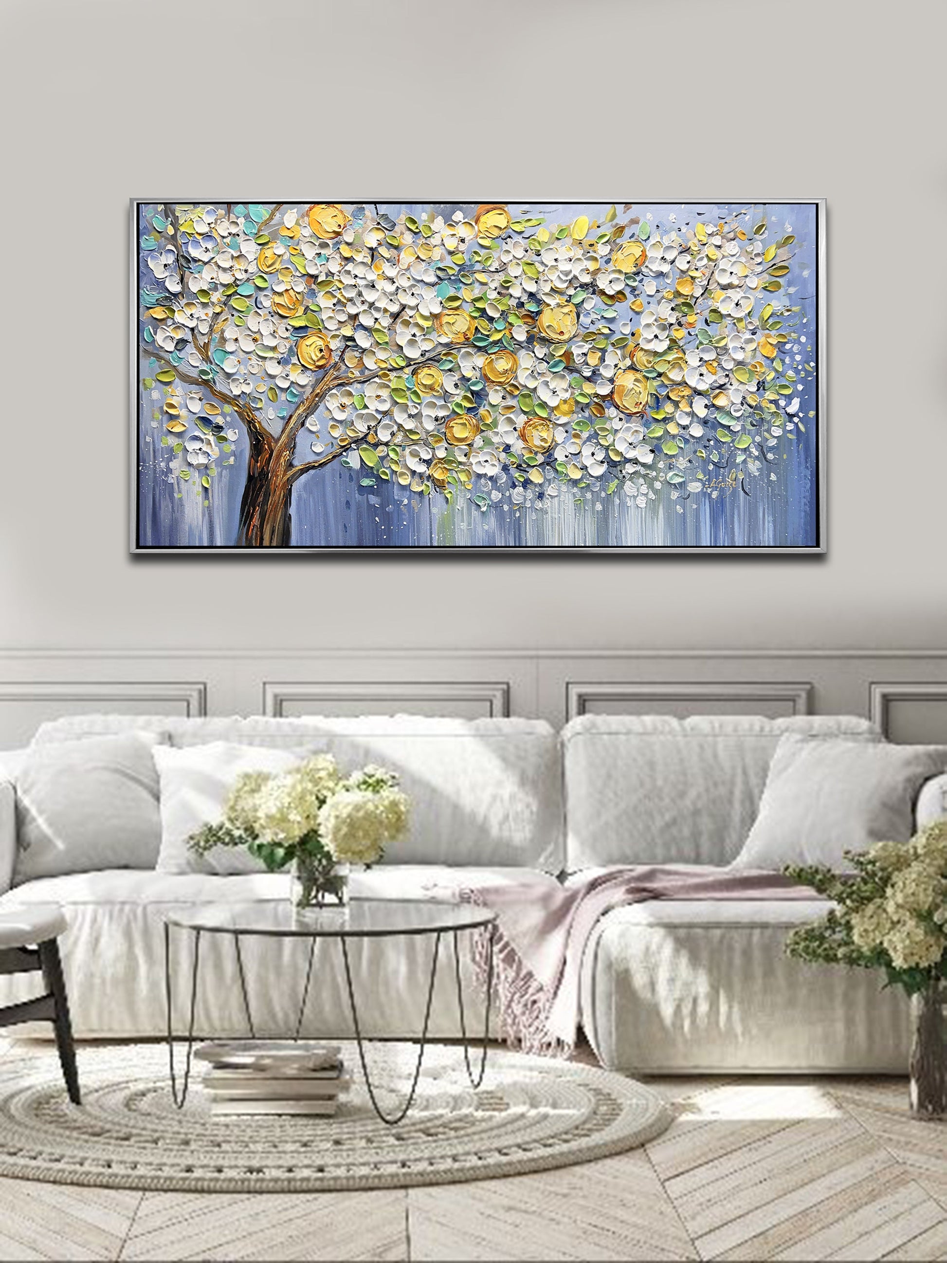 a living room with a white couch and a painting on the wall