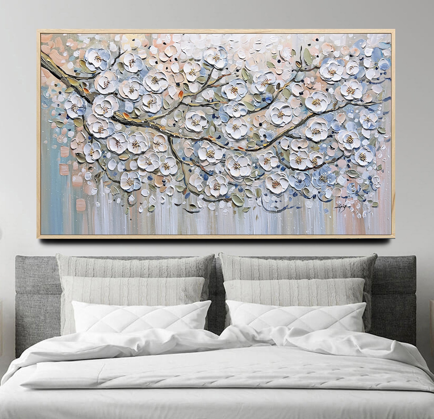 a bed with a white comforter and a large painting on the wall above it