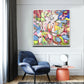 a living room with a blue chair and a painting on the wall