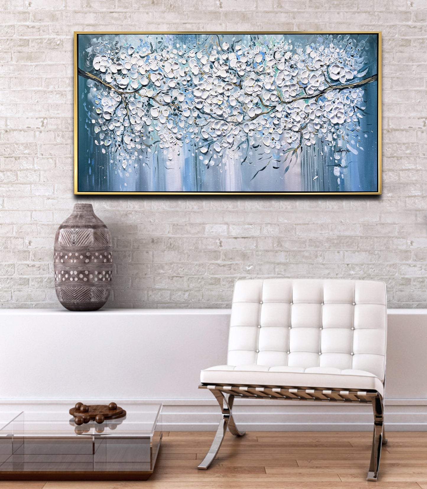 a white chair sitting in front of a painting on a wall