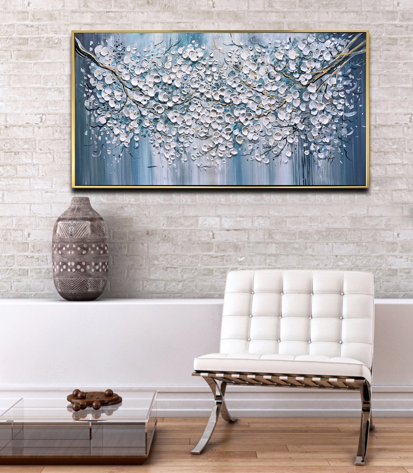 a white chair sitting in front of a painting on a wall