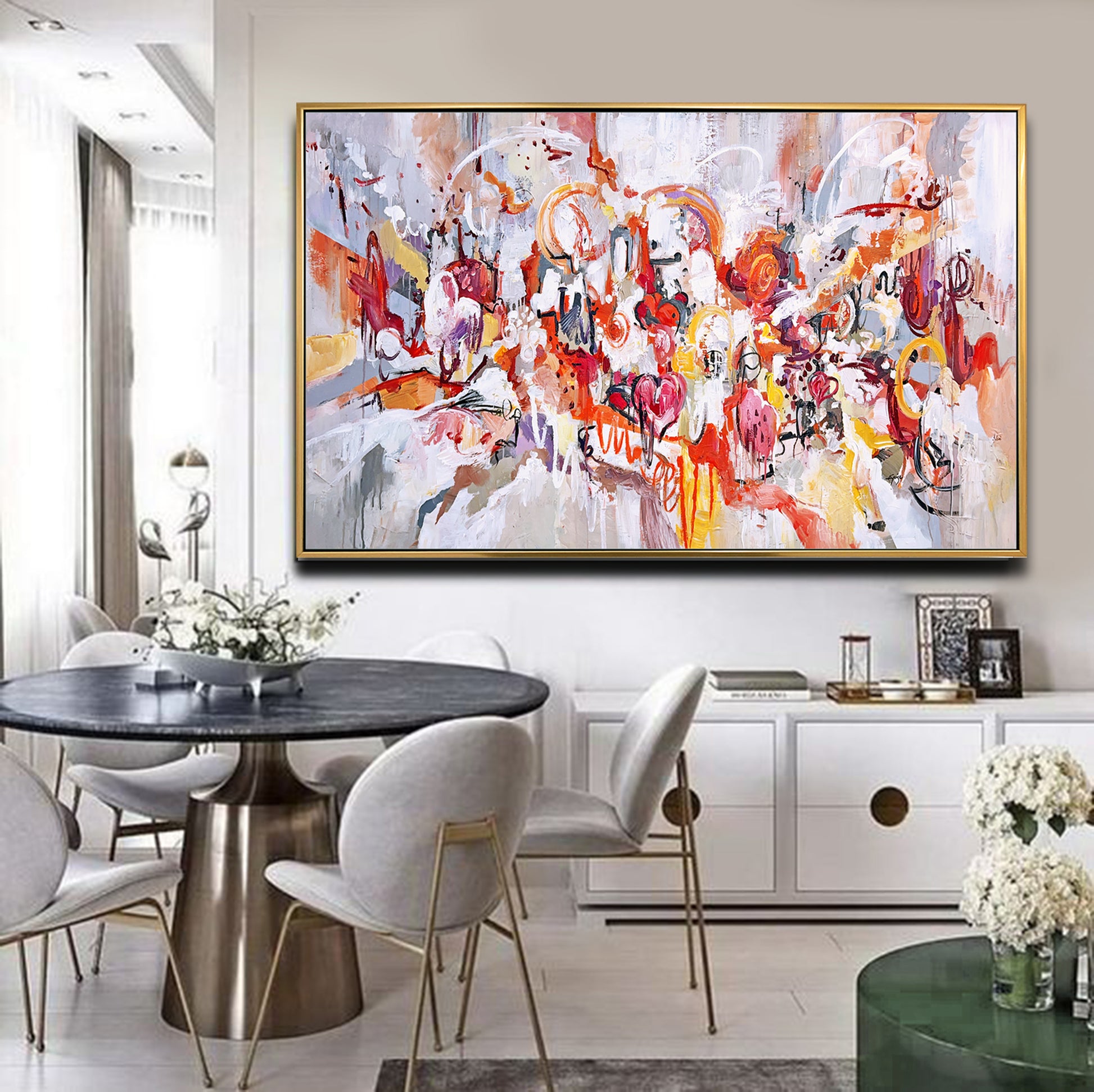 a painting hanging on a wall above a dining room table